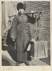 Itinerant ceramic repairman with tool boxes and gong called a tang or xiao lu jiang suspended from a shoulder pole