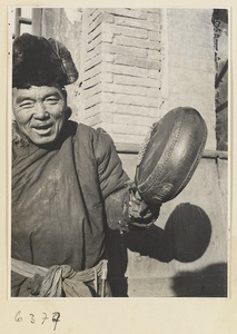 Itinerant charcoal seller holding a drum