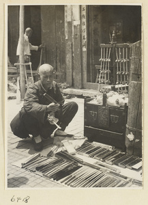 Fan vendor displaying his wares and strings of bells called chuan ling