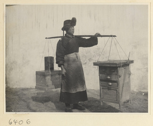 Tracery candy vendor with stove and stand suspended from a shoulder pole