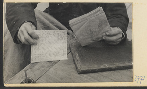 Paper-cut maker placing sheet with soot pattern on a stack of paper