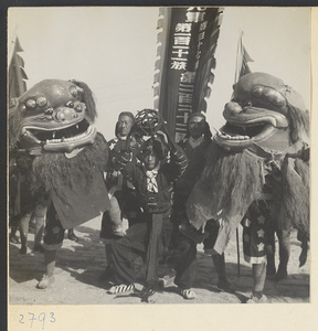Soldiers dressed in lion costumes and carrying a military unit banner at New Year's