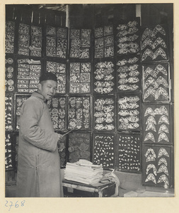 Paper-cut maker displaying wares for sale at his market stall