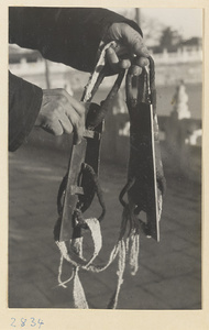 Ice skater holding skates at Beihai Lake