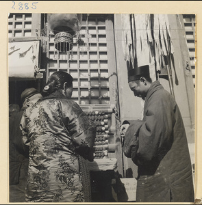 Woman and Daoist priest at an incense stand at New Year's