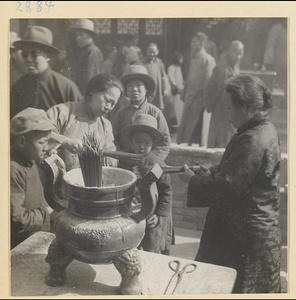 Women burning incense outside Bai yun guan at New Year's