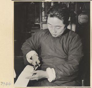 Man cutting cloth for a lantern in a lantern-making shop