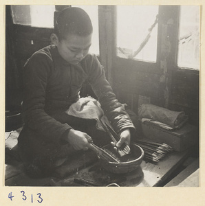 Boy making writing brushes in a brush-making shop