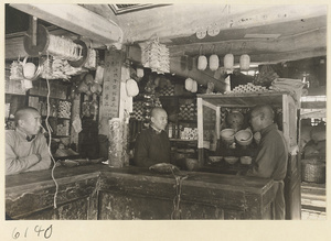 Shop interior showing three men behind a counter