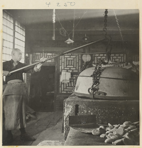 Baker tending an oven while making sesame cakes in a bakery