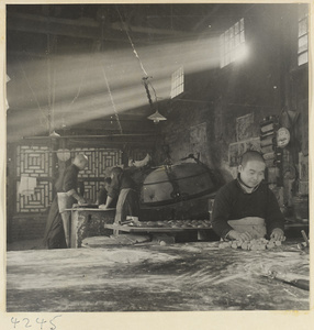 Men making sesame cakes in a bakery