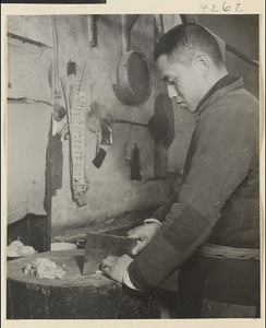 Restaurant interior showing a man chopping food with a cleaver