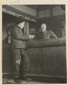 Restaurant interior showing a man eating at a counter and the proprietor