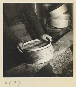 Man making a lid for a bamboo steamer in a workshop