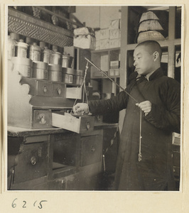 Tobacco shop interior showing a man loading tobacco onto a scale