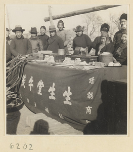 Patent medicine seller's stand with body-building ointments on display in front of a crowd at Tianqiao Market