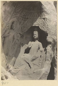 Detail of Wuzhou Cliff at Yun'gang showing cave entrance with statues of Buddha and attendants