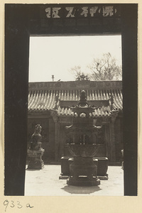 View through a temple doorway at the Yun'gang Caves showing courtyard with animal statue and incense burner