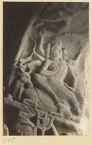 Interior of Cave 8 at Yun'gang showing a multi-headed, multi-armed figure seated on a horned animal