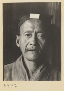 Daoist priest wearing a cap with a jade plaque on Hua Mountain