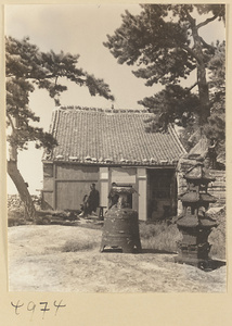 Bell with dew-collecting cup on top, incense burner, and Daoist priests in front of temple building on East Peak of Hua Mountain