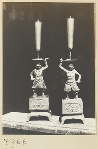 Two candlesticks with male caryatid figures in a Daoist temple on Hua Mountain