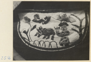 Embroidered purse from a village on the Shandong coast with design showing a human figure carrying an umbrella and an animal figure