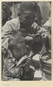 Man and girl eating in a village on the Shandong coast