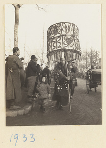Member of a funeral procession carrying an umbrella