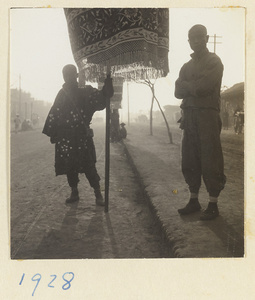 Men holding umbrellas for a funeral procession