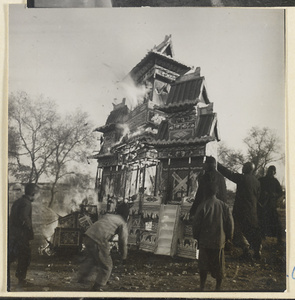 Paper replica of a building burning during a funeral service