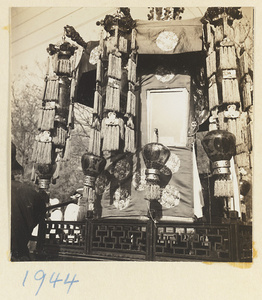 Structure with fringed banners and lanterns carrying soul tablet and portrait of the deceased in a funeral procession