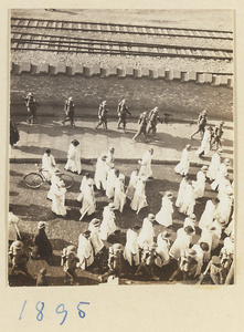 Members of a funeral procession dressed in white