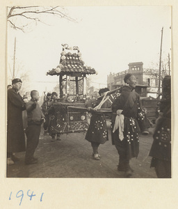 Members of a funeral procession carrying a paper pavilion