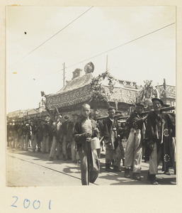 Coffin-bearers carrying draped coffin in funeral procession