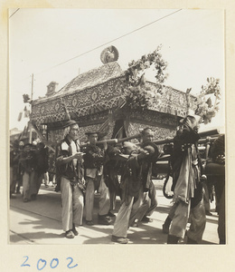 Coffin-bearers carrying draped coffin in funeral procession