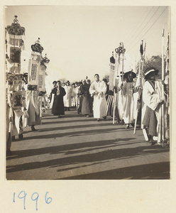 Members of a funeral procession carrying embroidered and inscribed banners