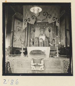 Temple interior on Miaofeng Mountain showing an altar with a statue of a goddess in a glass case