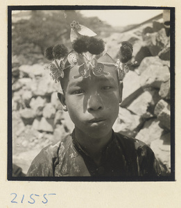 Boy pilgrim wearing a souvenir hat on the trail up Miaofeng Mountain