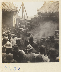Pilgrims next to a brick incense burner on Miaofeng Mountain