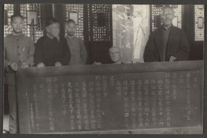 Five men holding a framed scroll