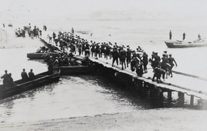 Japanese troops crossing a temporary bridge