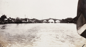 A three arched bridge photographed from a moving boat