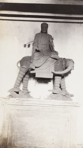 Wooden temple statue of Buddha riding an elephant