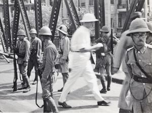Civilians walking past Japanese marines and a British soldier, Garden Bridge, Shanghai, 1937