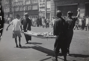 A stretcher party with a casualty, after the bombing of Sincere Company and Wing On department stores, Shanghai, 23 August 1937