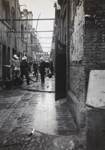 Shanghai Municipal Fire Brigade hosing down fires in an alleyway off North Szechuan Road, 1937
