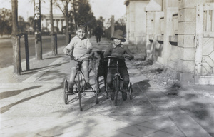 Donald and Gerald Johns on tricycles, with dog