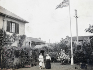 Group with gardener, in a garden with Union Jack flag