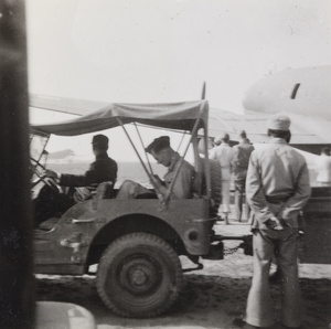 Jeep with trailer and airplane at an airfield, Sian